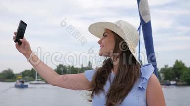 漂亮的女孩在游艇上自拍，手中的Android女人，节日照片，女人在你的手机上公开拍照。